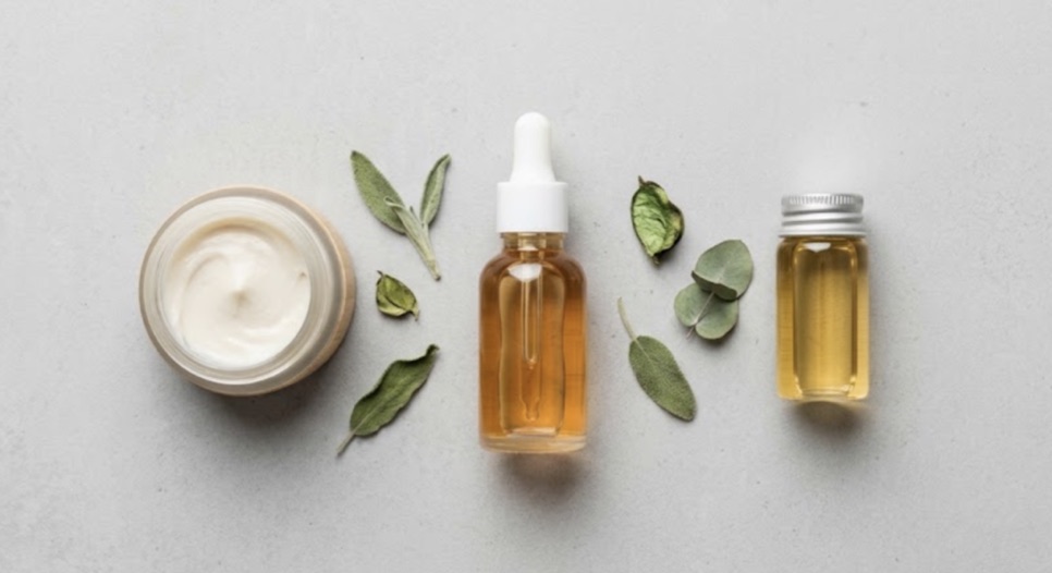 Krem kavanozu, serum şişesi ve yağ şişesi ile kurutulmuş bitki yaprakları